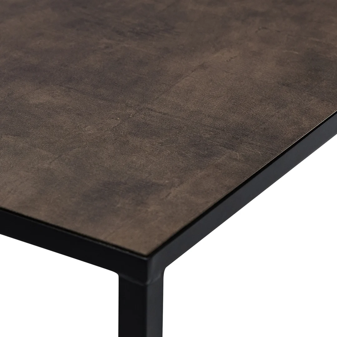 Een close-up van de hoek van Salontafel Zwart, Bruin 67 x 44 CM toont het donkere tafelblad met textuur en het strakke zwarte metalen frame.