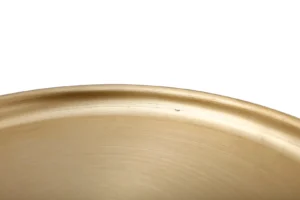 Close-up van de rand van de Bijzettafel Goud Rond Ijzer Design, een rond, goudkleurig metalen bijzettafeltje, tegen een witte achtergrond.