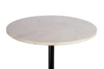 De Bijzettafel Roest heeft een rond wit marmeren tafelblad met subtiele grijze adering, ondersteund door een enkele zwart metalen poot, tegen een effen witte achtergrond.