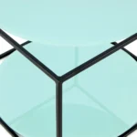 Close-up van de Bijzettafel Zwart, Groen Rond Metaal met twee ronde lichtblauwe glazen planken en een zwart metalen geometrisch frame.