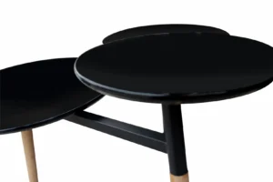 De Bijzettafel Zwart 30 CM Rond Bamboe heeft drie met elkaar verbonden zwarte ronde tafelbladen met bamboe poten op verschillende hoogtes, plus een opbergvak, allemaal tegen een witte achtergrond.