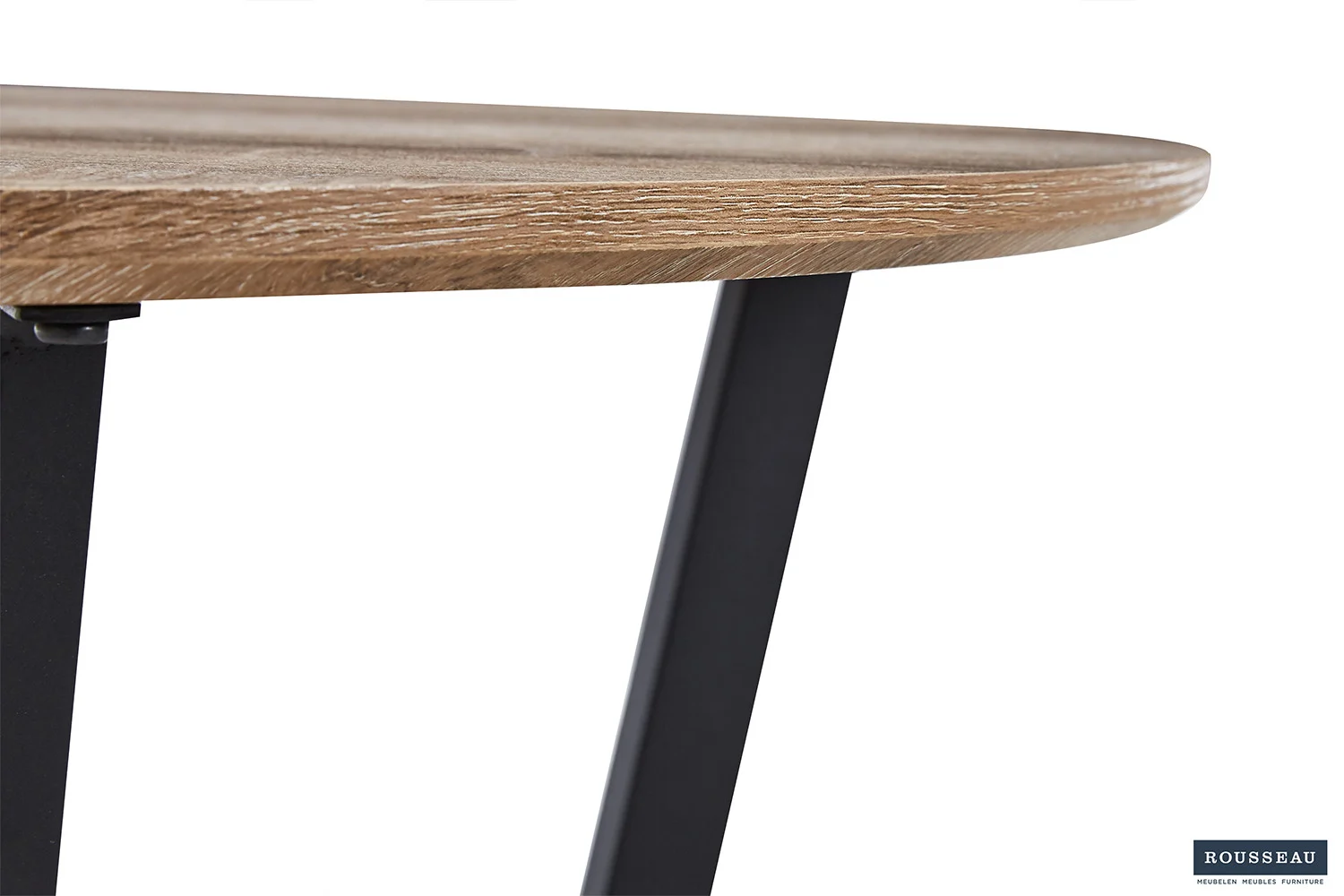 Close-up van de rand van de Salontafel Compact Klassiek, een ronde houten tafel met een natuurlijke afwerking en schuine zwarte metalen poten. Het Rousseau logo is zichtbaar in de rechter benedenhoek.