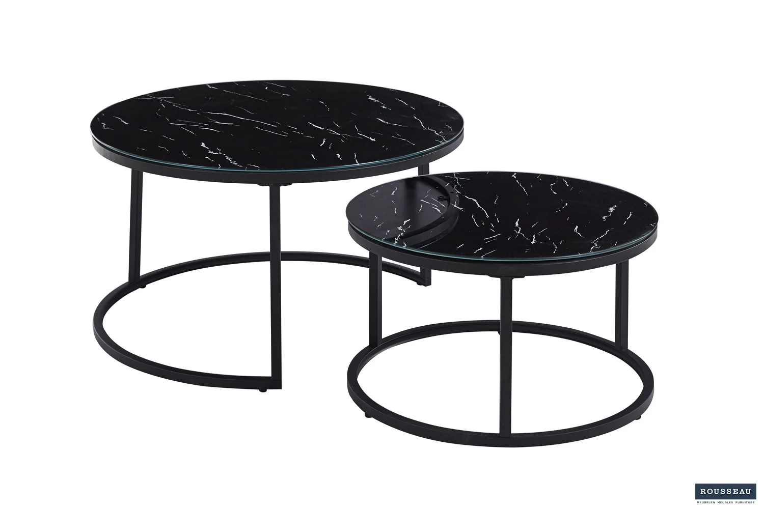 De Salontafel Zwart van Roest Marmer bestaat uit twee ronde salontafels met een zwart marmeren blad en een slank zwart metalen onderstel. De kleinere tafel past gedeeltelijk onder de grotere, wat een moderne, minimalistische look benadrukt.