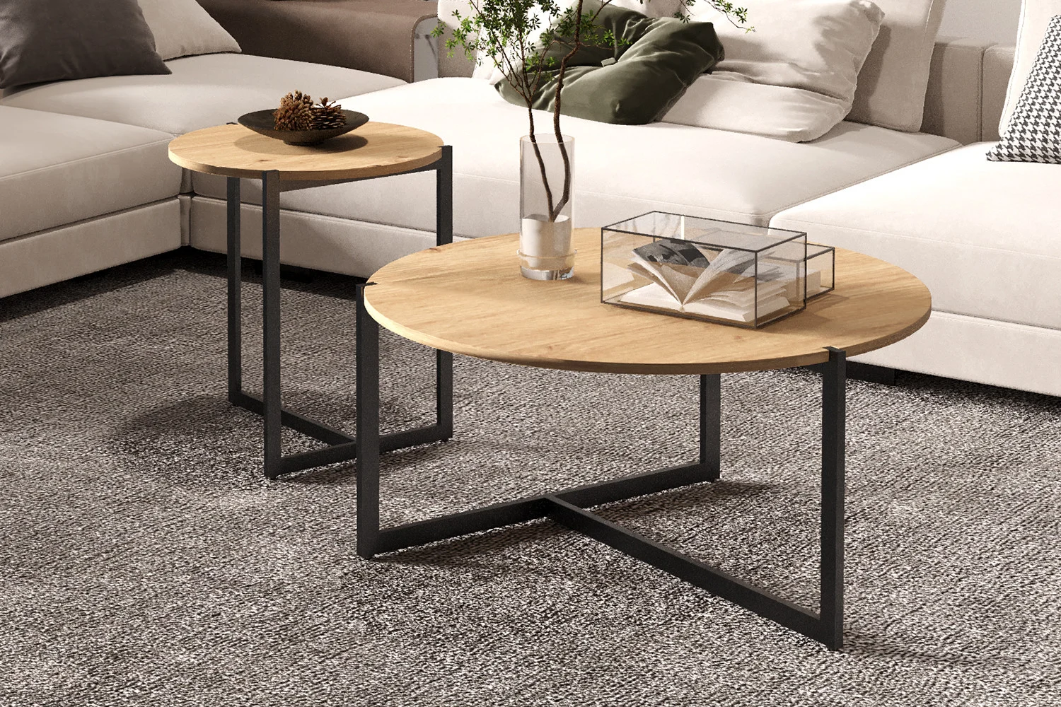 Twee Salontafel Klassiek Design Tijdloos tafels met zwarte metalen poten staan op een grijs tapijt in de woonkamer. Op de ene staat een glazen vaas met groen, op de andere een schaal met dennenappels. Een beige sofa verschijnt op de achtergrond.