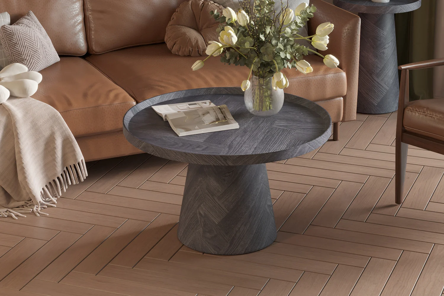 De Salontafel Donkergrijs, Roest 80 CM met een gestructureerde afwerking staat op een lichthouten visgraatvloer, met daarop een vaas met witte tulpen en een tijdschrift. Op de achtergrond staat een bruine bank gedrapeerd met een kleed.