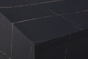 Een close-up van de Bijzettafel Zwart MDF Design heeft een zwart oppervlak met dunne, elkaar kruisende lichtlijnen die geometrische vormen vormen, wat de tafel een minimalistisch abstract uiterlijk geeft.