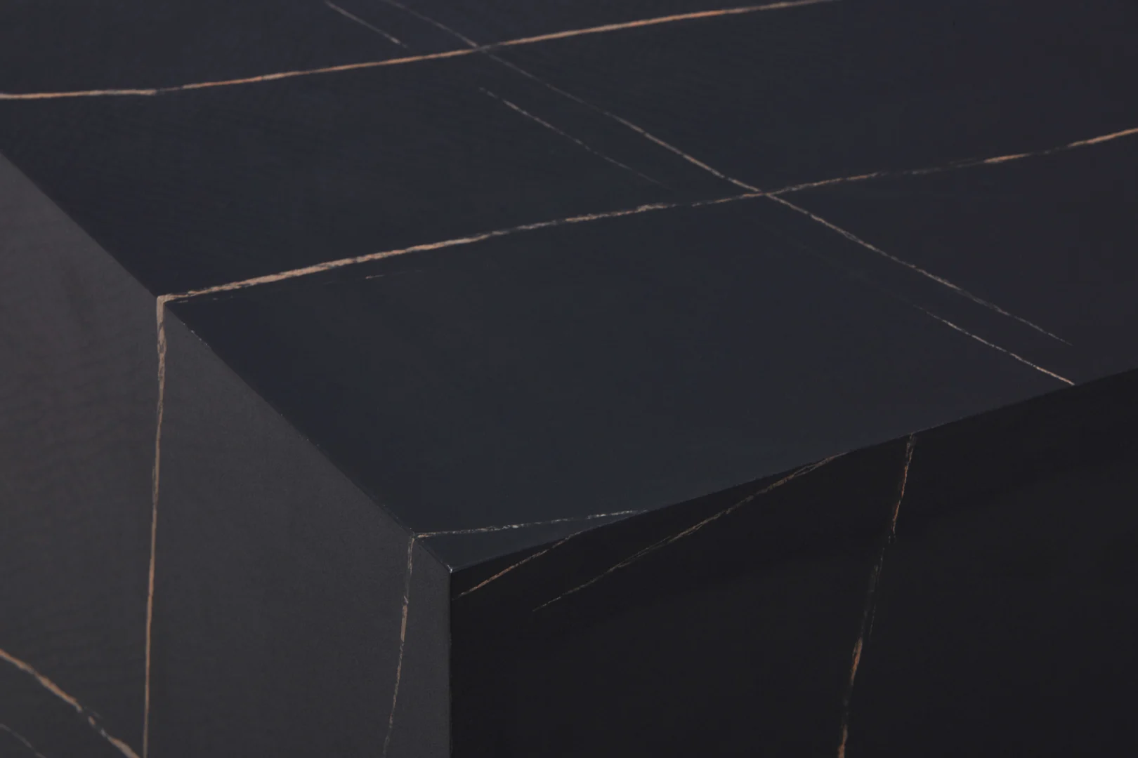 Een close-up van de Bijzettafel Zwart MDF Design heeft een zwart oppervlak met dunne, elkaar kruisende lichtlijnen die geometrische vormen vormen, wat de tafel een minimalistisch abstract uiterlijk geeft.