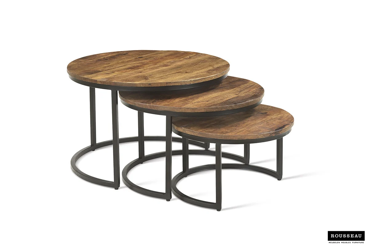 De Salontafel Roest Mangohout Design heeft drie ronde nesttafels met mangohouten bladen en zwarte metalen poten, gerangschikt van groot naar klein in een moderne, minimalistische stijl. Perfect om gedeeltelijk onder elkaar te schuiven.