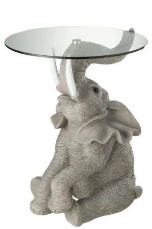 De Bijzettafel Greige, Grijs 63 CM Glas is een ronde glazen bijzettafel met een gedetailleerd beeld van een grijze olifant met opgeheven slurf, zichtbare slagtanden en grote gespreide oren als basis.