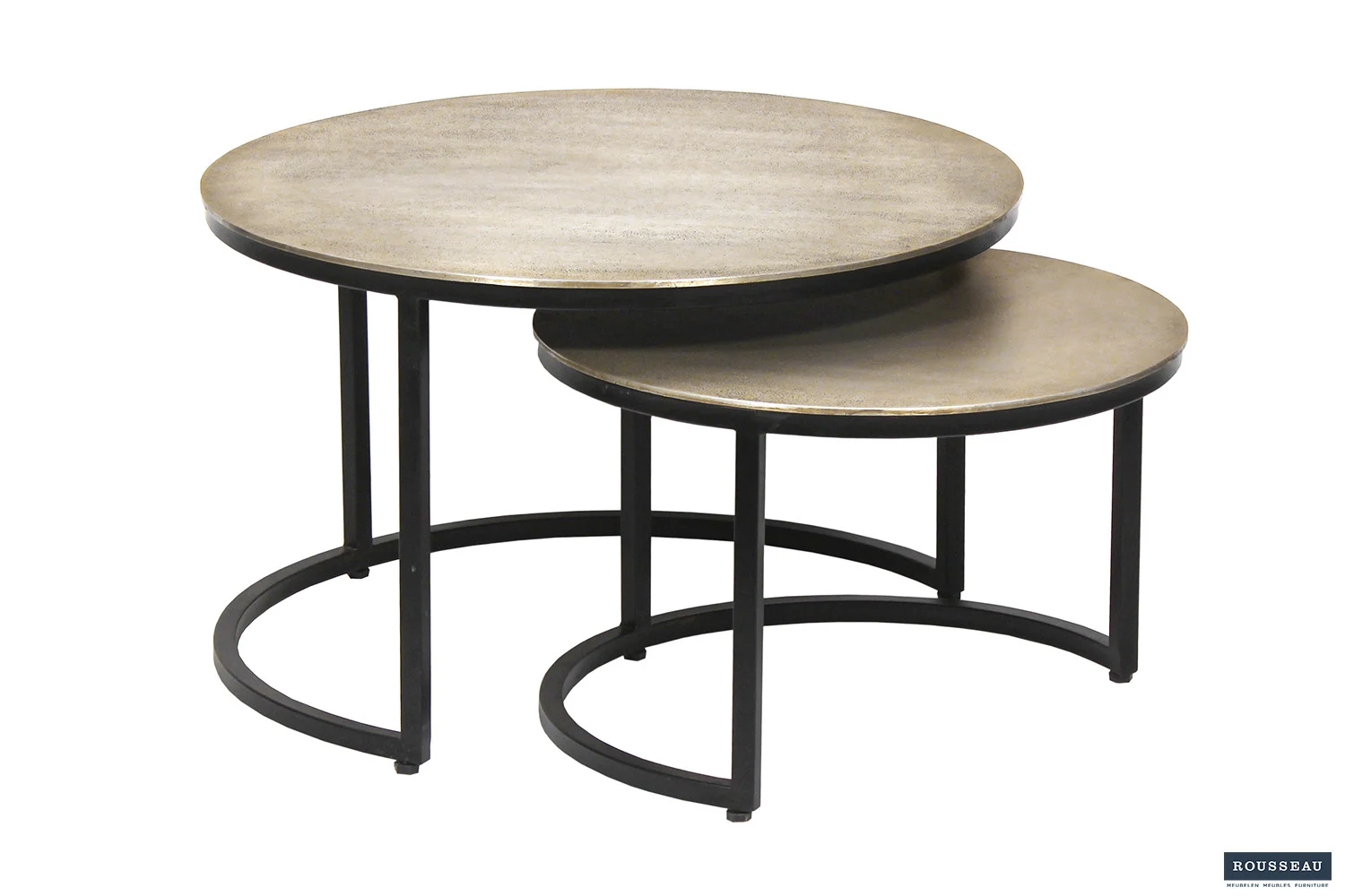 De Salontafel Zilver Compact bestaat uit twee ronde nesttafels met een zilver metallic blad en zwarte metalen poten. De kleinere tafel past gedeeltelijk onder de grotere, voor een ruimtebesparende, moderne look.