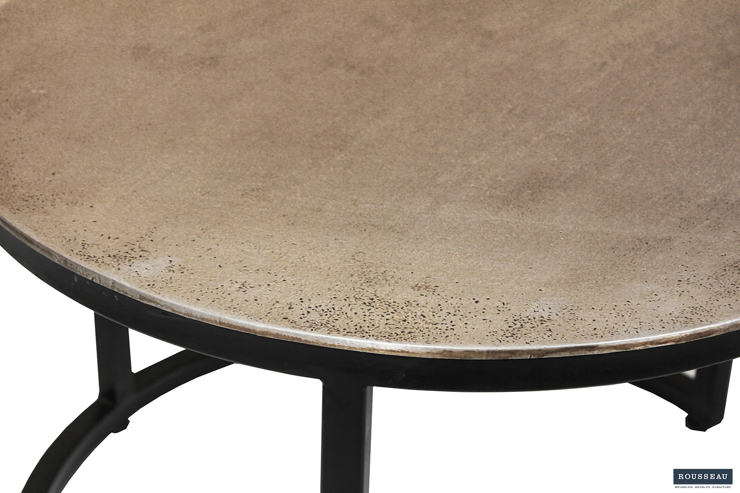 Een close-up van de Salontafel Zilver Compact onthult het gladde, beige stenen blad met subtiele natuurlijke textuur en kleurvariaties, ondersteund door een slank zwart metalen frame en poten.