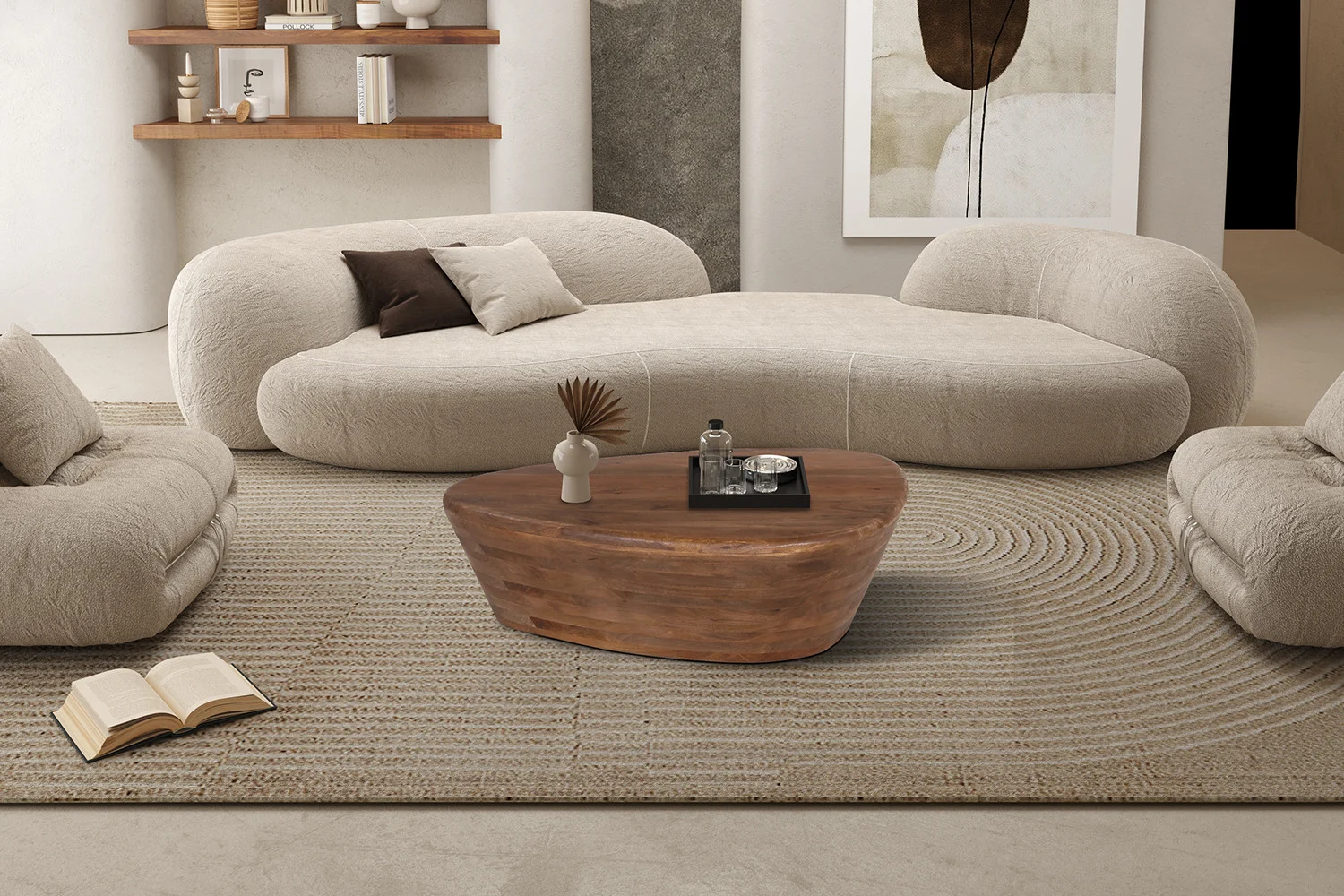 Een gezellige, minimalistische woonkamer met gebogen crèmekleurige sofa's, een Salontafel Mangohout Industrieel Modern met decor, een beige vloerkleed met textuur, een open boek op de vloer, planken met decoraccenten en abstracte muurkunst.