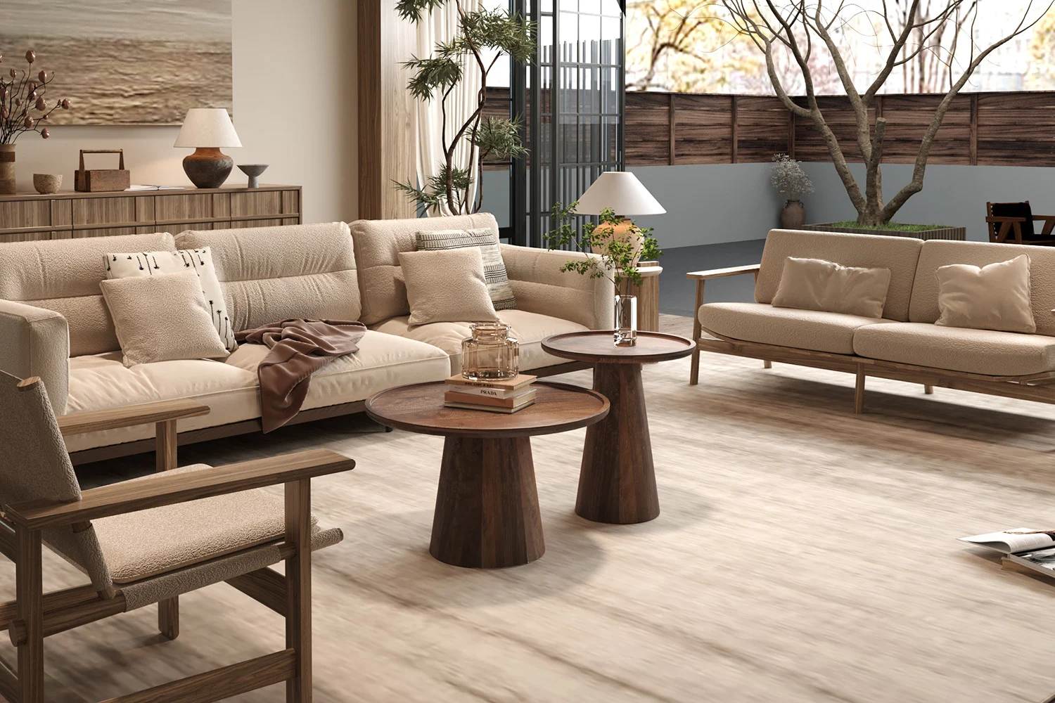 In een moderne woonkamer met beige banken, fauteuils en neutrale kussens staat de Salontafel 45 x 50 CM Rond Mangohout, omringd door kamerplanten. Grote ramen bieden uitzicht op een omheinde buitenruimte met bomen en zonlicht.