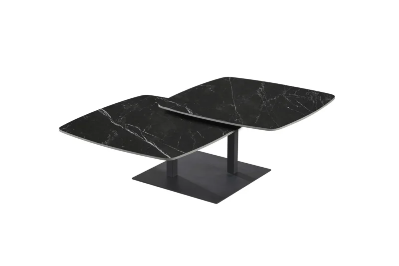 De Salontafel Zwart Rond Steen is een moderne salontafel met twee overlappende, vierkante zwart marmeren bladen met witte adering, ondersteund door een centrale dubbele voet op een plat rechthoekig plateau.