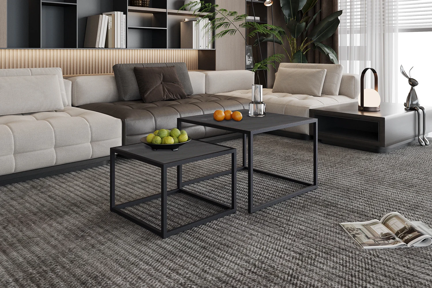 Moderne woonkamer met een beige sectionele bank, Salontafel Zwart Mangohout Compact als nesting black salontafels met fruit en een karaf, lage bijzettafel met lamp en sculptuur, grote groene plant en tijdschriften op een grijs getextureerd tapijt.