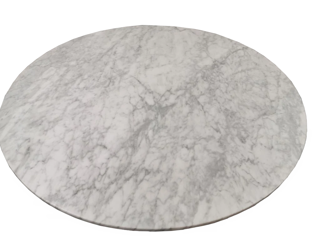 De Ronde eettafel van koraal in marmer en geborsteld roestvrij staal heeft een rond, plat tafelblad van wit marmer met grijze adering, van bovenaf gezien tegen een witte achtergrond.