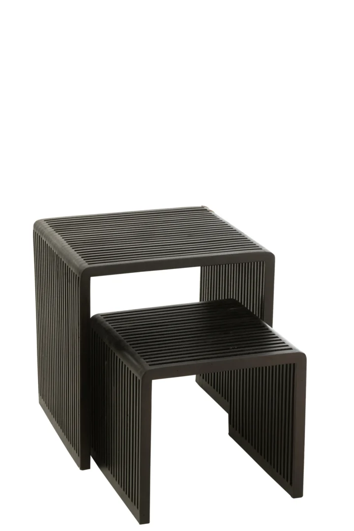 De Set van 2 salontafels Kubus Recycle Teak Zwart bestaat uit twee moderne, zwarte rechthoekige nesttafels met latten aan de zijkanten. De kleinere tafel past gedeeltelijk onder de grotere, beide met een minimalistisch, open ontwerp tegen een witte achtergrond.