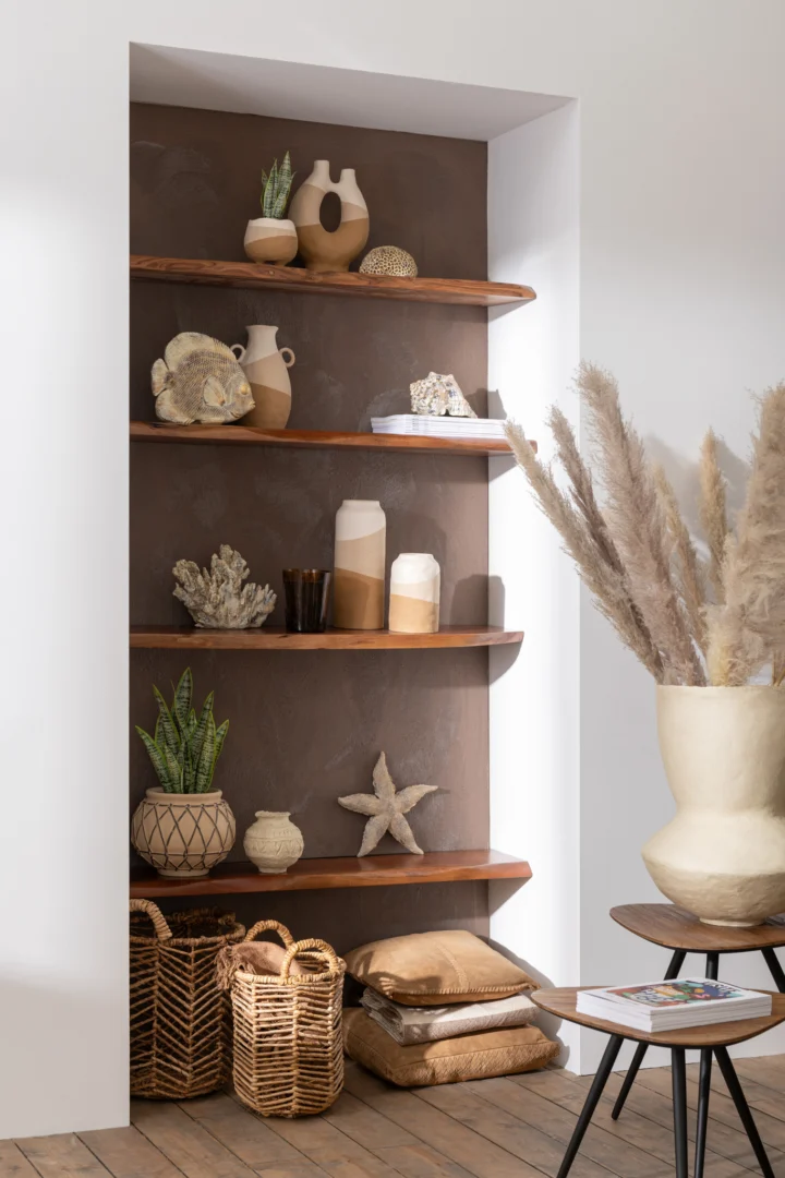 In de Set van 2 tafels Driehoek Recycle Teak Natuurlijk staan vazen, aardewerk, zeesterren, koraal en potplanten, aangevuld met nabijgelegen gevlochten manden, beige kussens en hoog pampagras voor een natuurlijke, aardse sfeer.