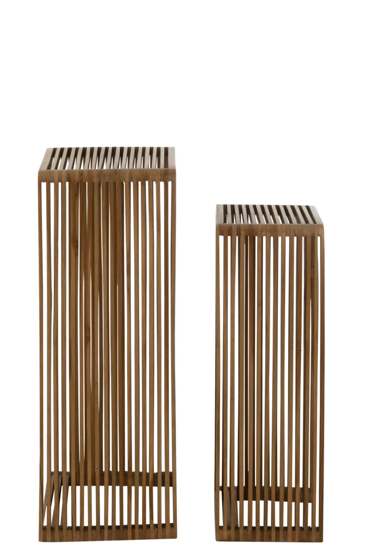 De Set van 2 bijzettafels Kubus Recycle Teak Natuurlijk bestaat uit twee bijzettafels van verschillende hoogtes, gemaakt van verticale gerecyclede teakhouten latten met open tussenruimtes voor een moderne, luchtige uitstraling. De lange tafel staat links, de korte rechts.