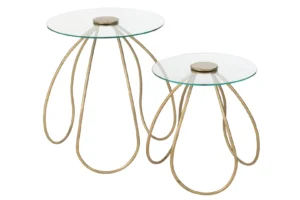 De Bijzettafel Goud Rond Metaal set bestaat uit twee moderne bijzettafels met ronde glazen bladen en gouden metalen onderstellen met een lusvormig open ontwerp; de ene tafel is iets hoger dan de andere.