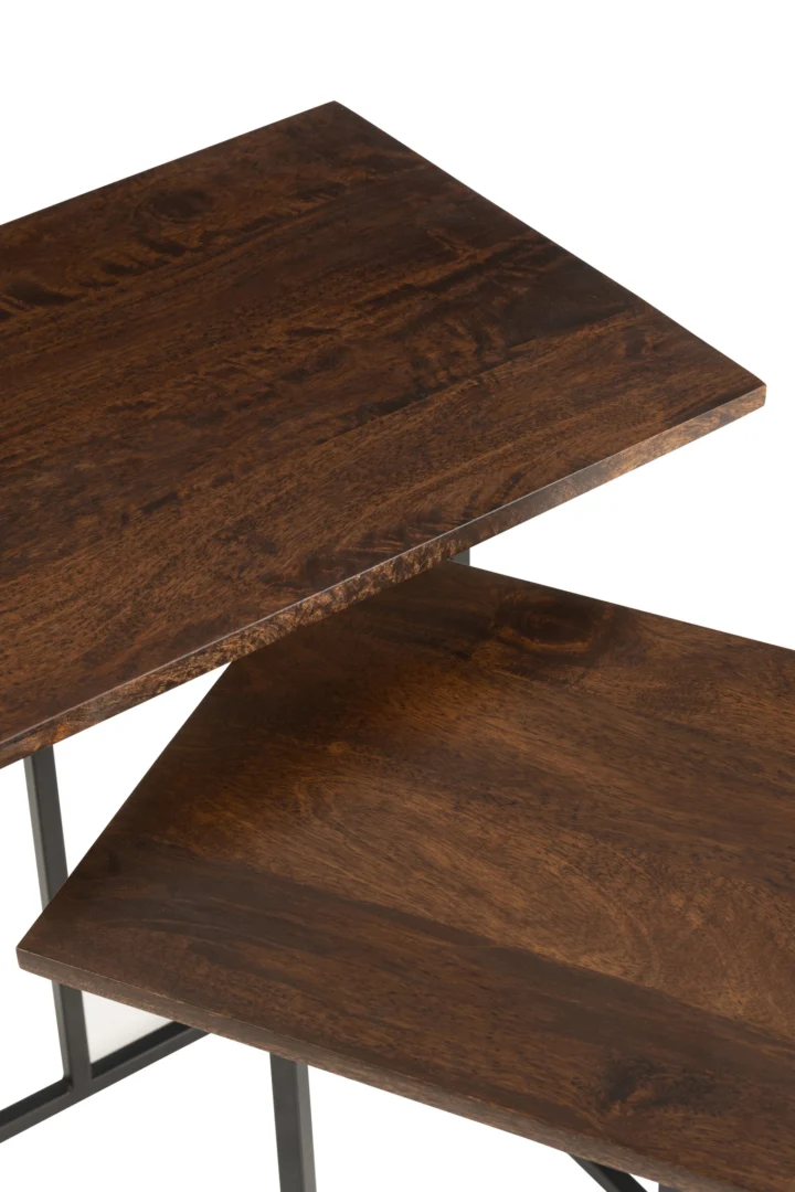 Close-up van twee overlappende Bijzettafel Zwart, Bruin 50 CM Rechthoek gemaakt van mangohout met een rijke donkerbruine afwerking en zichtbare houtnerf, ondersteund door slanke zwart metalen poten.