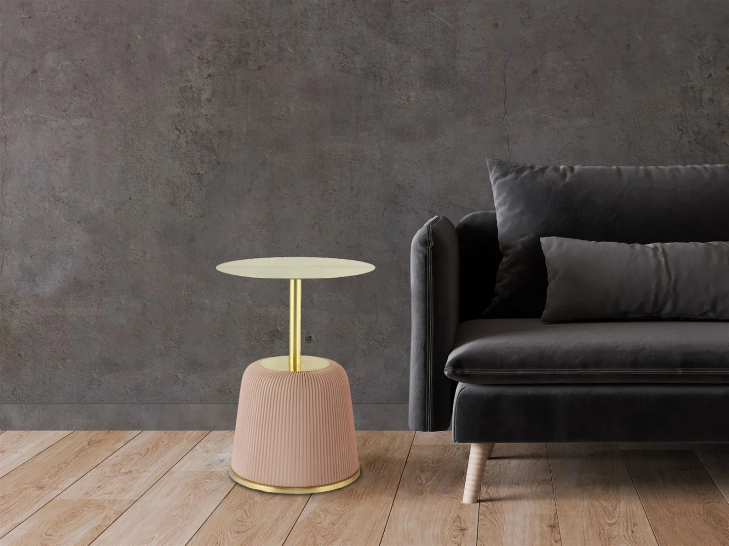 Een moderne woonkamer met een donkergrijze fluwelen bank en de Bijzettafel Roze Rond Ijzer Scandinavisch - een ronde bijzettafel met een gouden blad en een blush roze onderstel - tegen een donkere muur met textuur en een lichte houten vloer.