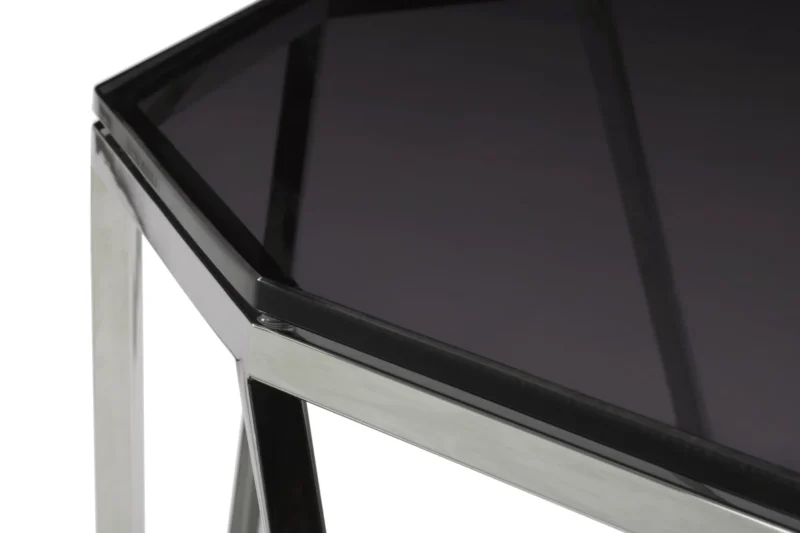 Close-up van de Aria gerookt glas en gepolijst roestvrijstalen bijzettafel met een donker, getint glazen blad en een gepolijst roestvrijstalen frame met strakke, hoekige lijnen en een glanzende afwerking.