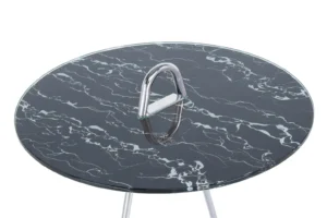 De Bijzettafel Zilver, Zwart Staal is een ronde glazen tafel met een zwart marmerpatroon en een moderne driehoekige zilveren metalen handgreep in het midden, van bovenaf gezien.