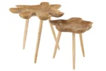 Een paar Bijzettafels Teakhout 60 x 60 CM met organisch gevormde teakhouten bladen en elk drie slanke poten. Ze staan op verschillende hoogtes en hebben een natuurlijke afwerking die de houtnerf benadrukt.
