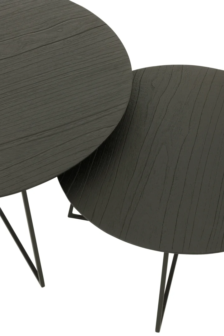De Bijzettafel Zwart 80 x 80 CM Rond heeft ronde teakhout bladen met een donkere houtnerf en dunne zwart metalen poten, gedeeltelijk overlappend tegen een witte achtergrond.