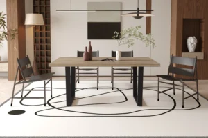 Een moderne eetkamer is voorzien van de UITVERKOOP - Tafel 'Armin' 180 cm Decor Mango, vier stoelen, minimalistische inrichting, een vaas met een tak op tafel bovenop een wit vloerkleed met zwarte lijnen, plus kunstwerken, planken en warme verlichting.