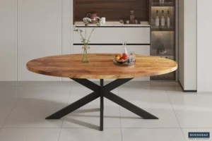 De Tafel 'Alexa' 200 cm Ovaal Mango hout met zwart metalen poten staat op een tegelvloer. Op tafel staan vazen met bloemen, een fruitschaal en een glazen karaf, met moderne keukenkastjes op de achtergrond.