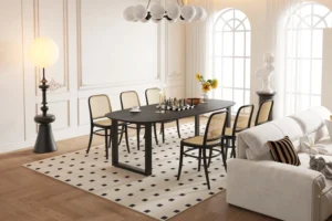 Elegante eetkamer met de UITVERKOOP - Tafel 'Tommy' 220x100 cm Deens Ovaal U-Poot in zwart mangohout, schaakset en omringd door zes stoelen met rieten rugleuning, met zonlicht dat een witte bank, staande lamp, beeld en vazen op een gedessineerd tapijt verlicht.