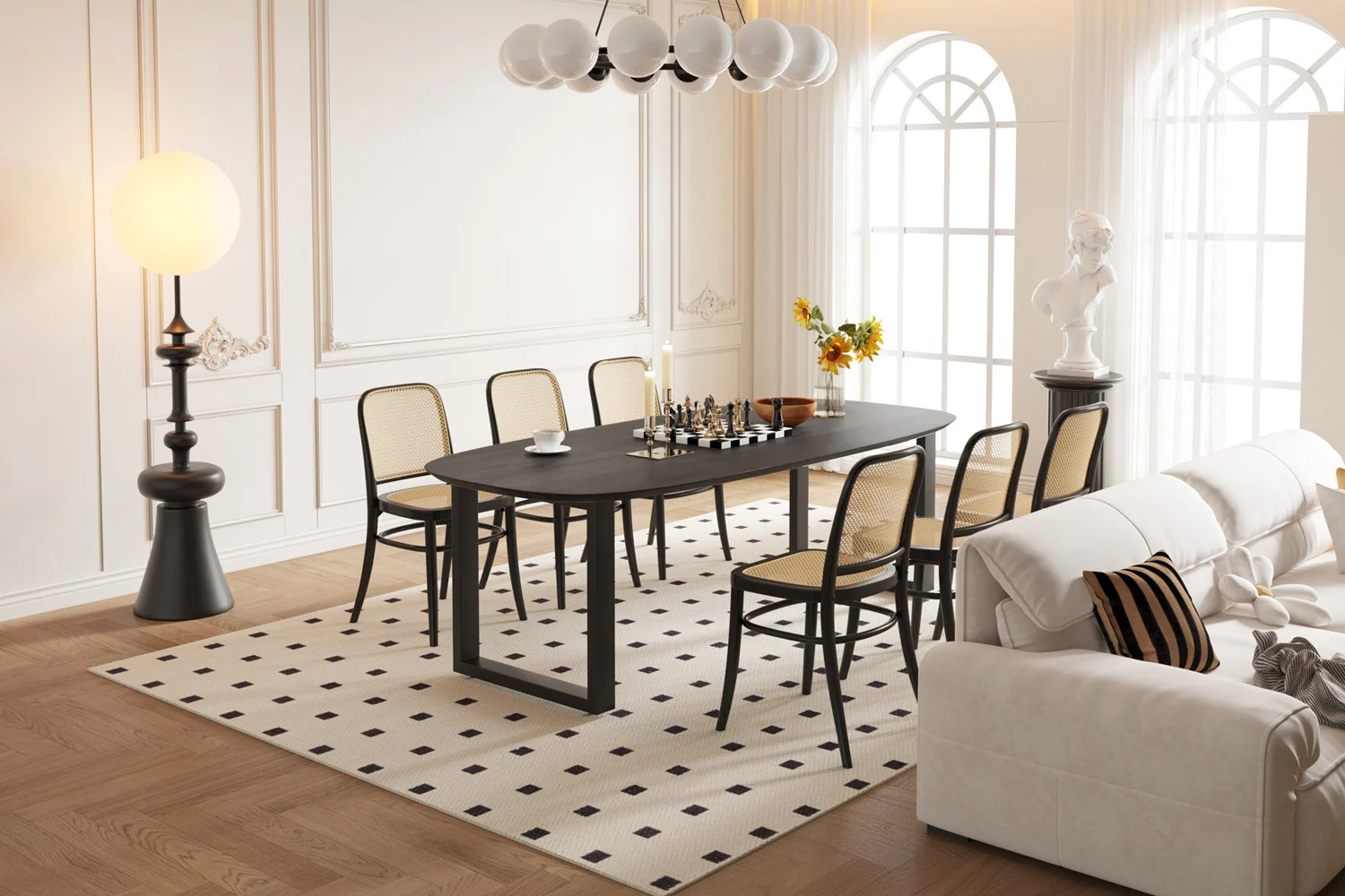 Elegante eetkamer met de UITVERKOOP - Tafel 'Tommy' 220x100 cm Deens Ovaal U-Poot in zwart mangohout, schaakset en omringd door zes stoelen met rieten rugleuning, met zonlicht dat een witte bank, staande lamp, beeld en vazen op een gedessineerd tapijt verlicht.