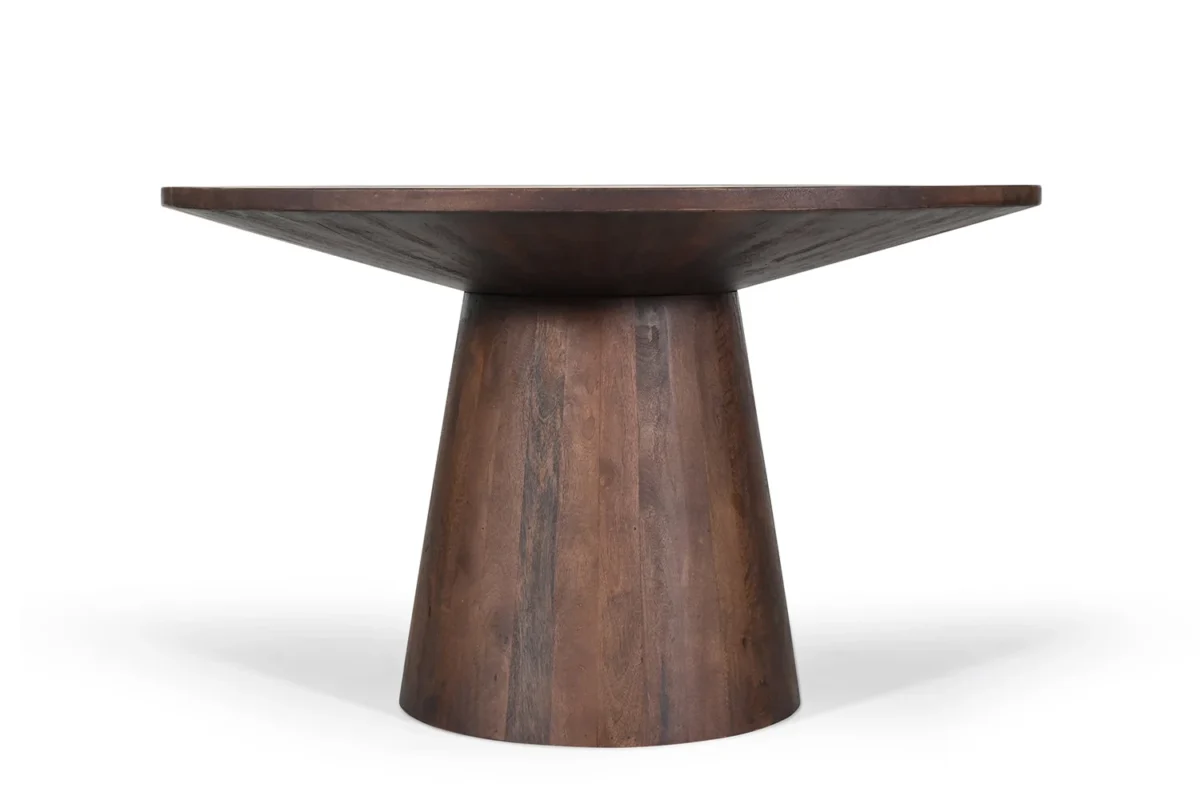 De Tafel 'Tommy' is een 130 cm ronde tafel gemaakt van bruin mangohout, met een breed rond blad en een stevig conisch onderstel in een modern, minimalistisch ontwerp, afgebeeld op een effen witte achtergrond.