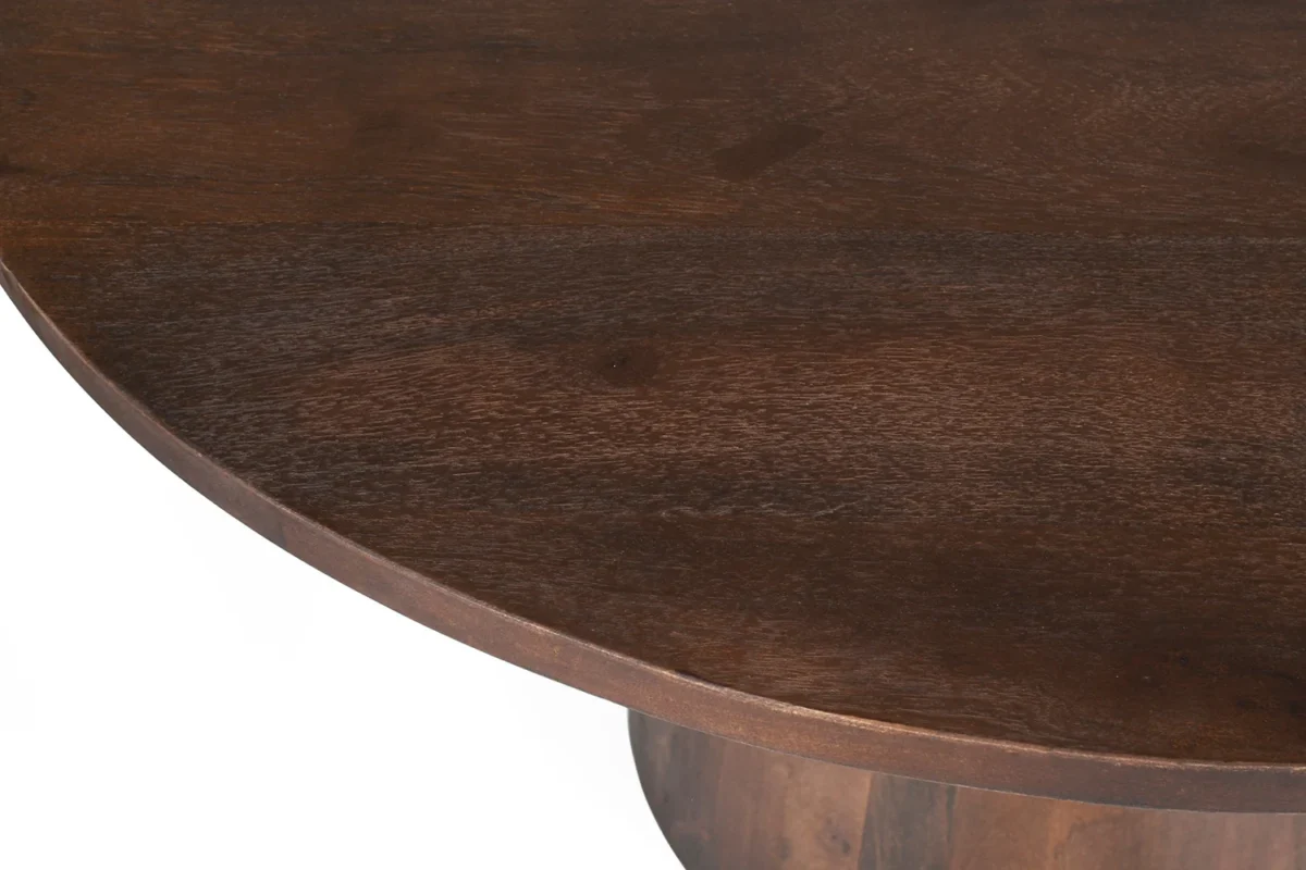 Close-up van de rand van de Tafel 'Tommy' 130 cm ronde mangohouten tafel in bruin, met een gladde afwerking tegen een witte achtergrond.