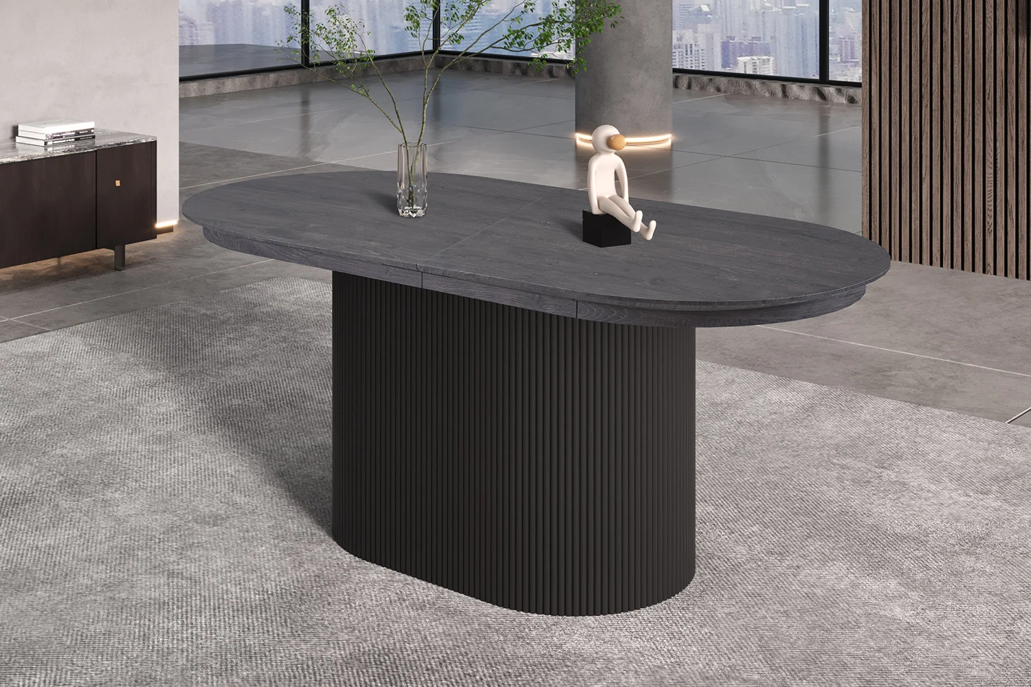 De Uitschuifbare tafel 'Lagos' 180-220 cm Ovaal Decor Donkerbruin staat op een licht tapijt met een heldere vaas met groene takken en een klein abstract beeld erop, ondersteund door grote ramen met stadsgebouwen.