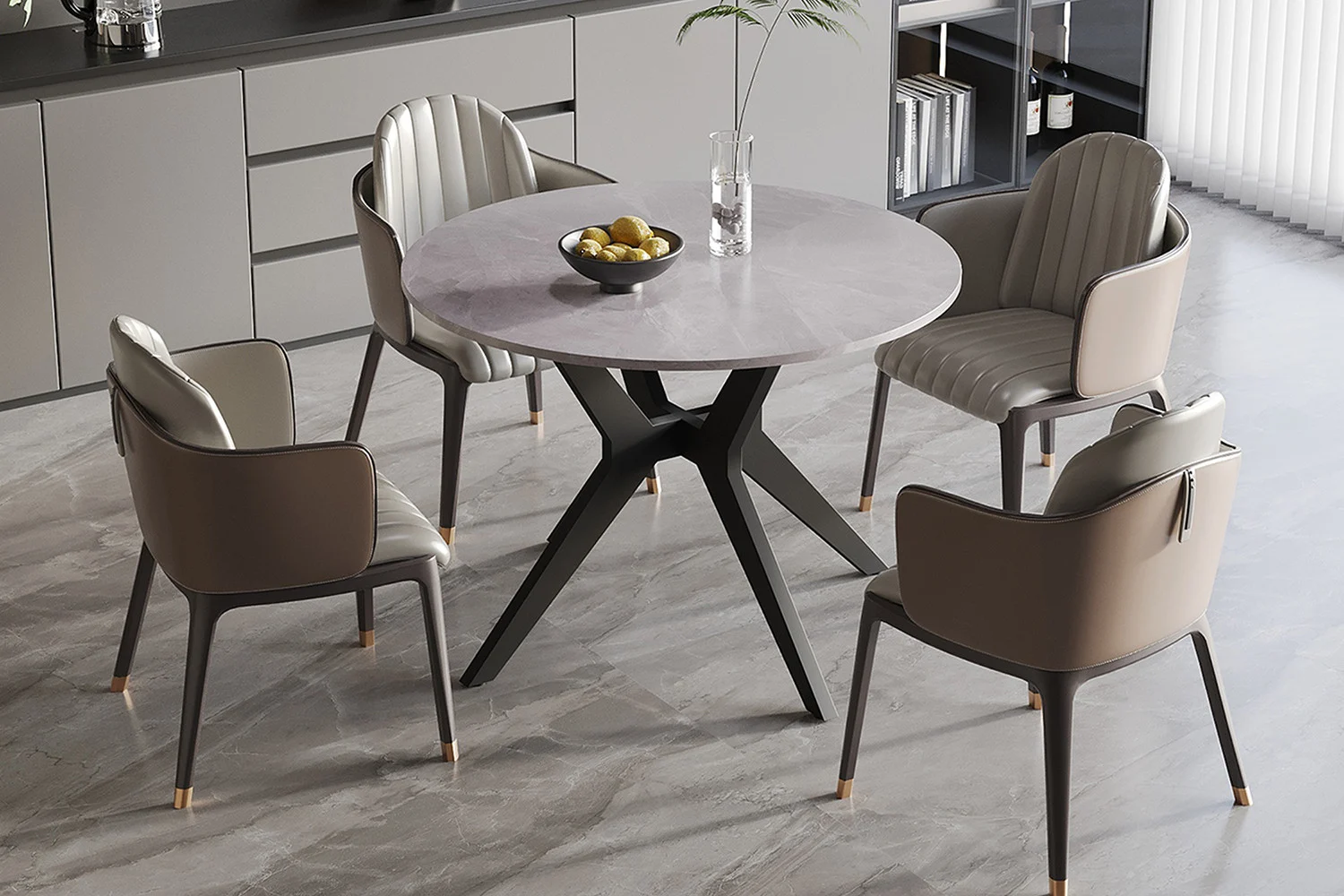 De Tafel 'Apollo' ronde tafel van 110 cm heeft een glanzend Italiaans grijs steenachtig oppervlak en zwarte poten, omringd door vier gecapitonneerde taupe stoelen. Op de tafel staan een glazen vaas met een plant en een fruitschaal; de kamer heeft grijze kasten en betegelde vloeren.