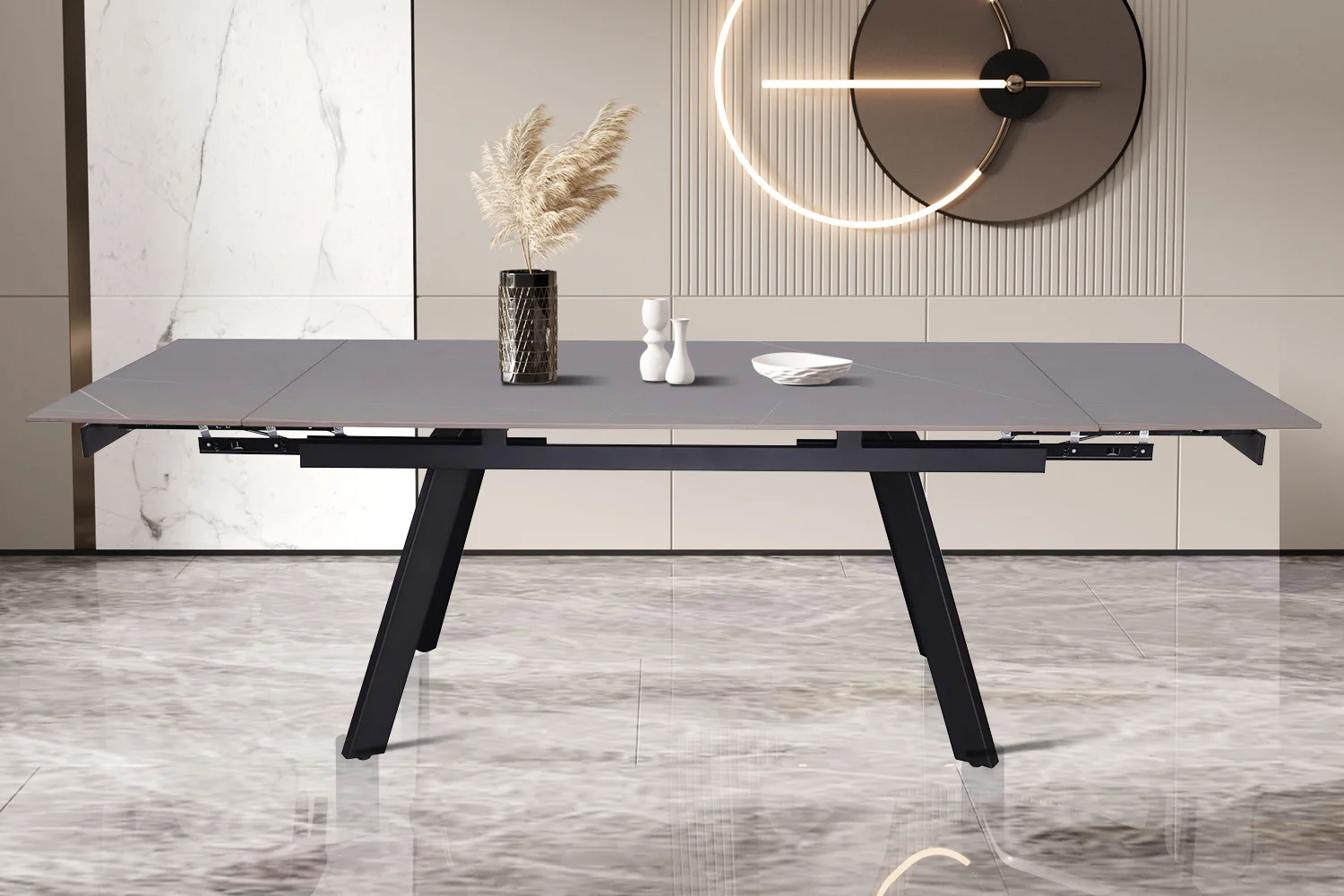 De UITVERKOOP - Uitschuifbare tafel 'Hera' 160-240 cm Rechthoekig Steen Grijs heeft schuine zwarte poten en een grijs blad, geplaatst op een marmeren vloer met decor waaronder een vaas, twee sculpturen en een bord. Een minimalistische klok hangt erachter.