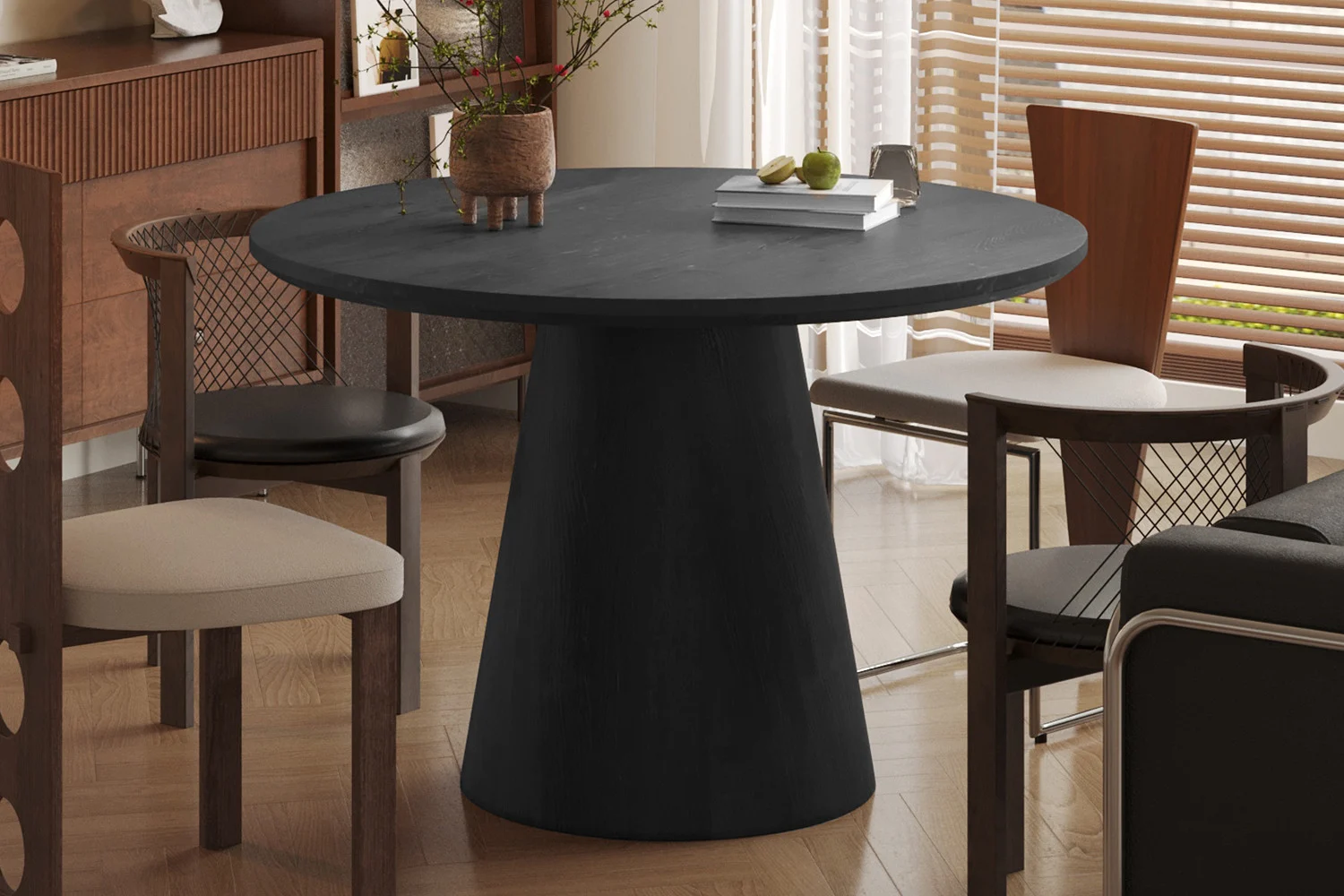 Een moderne eetkamer met de 'Miklos' 120 cm ronde donkerbruine tafel, vier stoelen met lichte kussens, een vaas met takken erop, een houten vloer en zonlicht dat door de jaloezieën naar binnen schijnt.