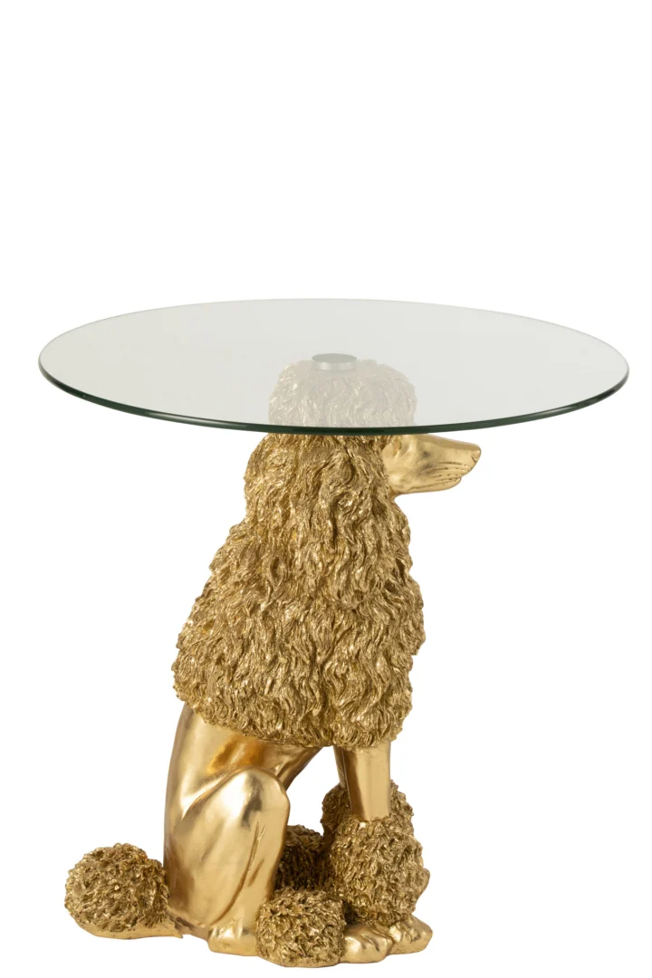 De Bijzettafel Poedel Rond Polyresin Goudkleurig heeft een helder rond glazen blad dat wordt vastgehouden door een zittende gouden poedel met gebeeldhouwde krullende vacht.