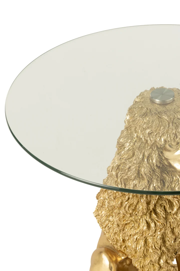 Een ronde tafel van glas met de naam Bijzettafel Poedel, met een goudkleurig onderstel van polyresin in de vorm van een leeuwenkop en -manen, waarbij het bovenste gedeelte van de leeuw het ronde glazen oppervlak ondersteunt.
