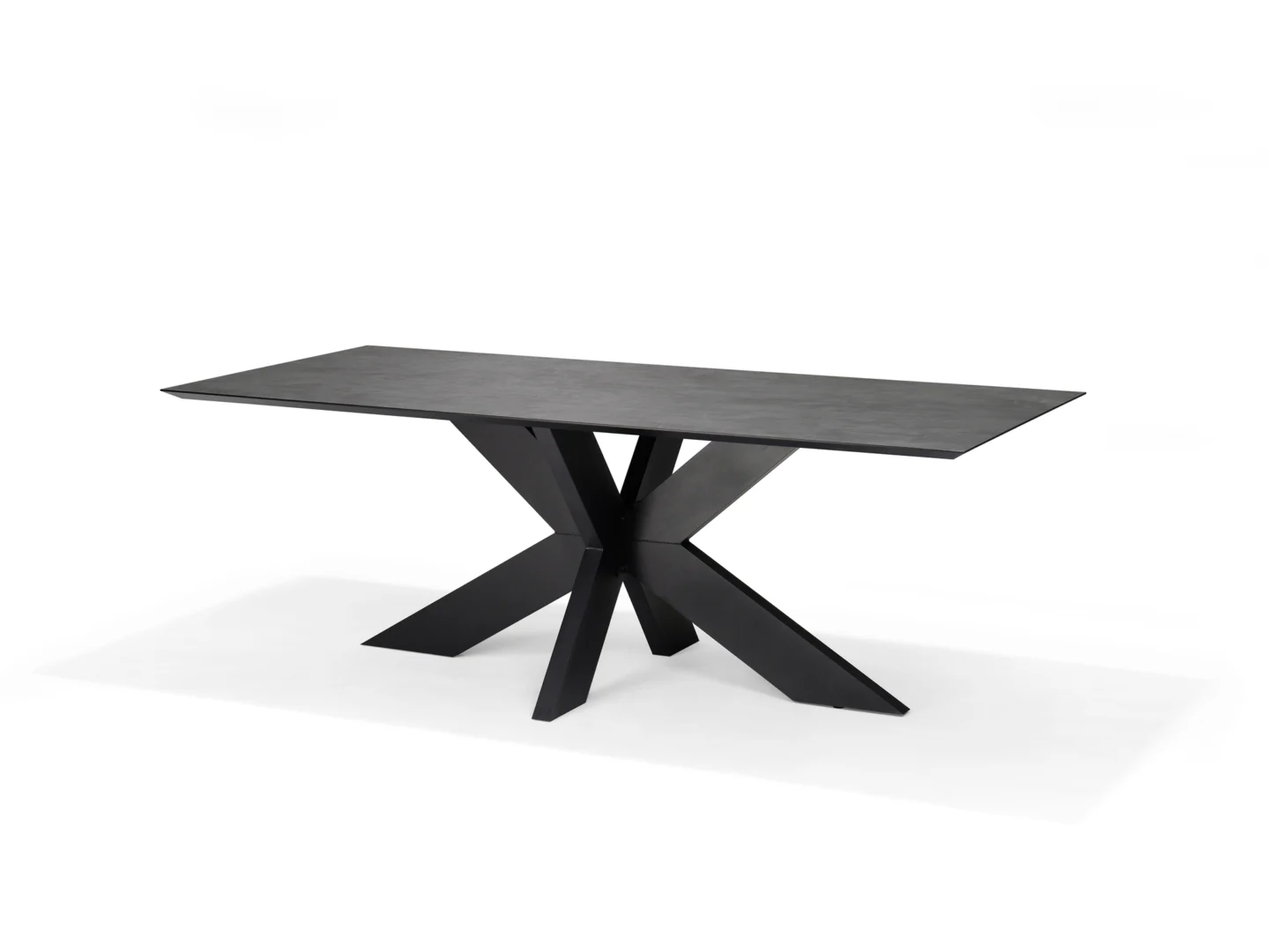 De Schakel Eettafel 220x100 is een moderne rechthoekige zwarte tafel met een glad keramisch blad en een kruisend geometrisch onderstel, tegen een effen witte achtergrond.