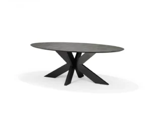 De Schakel Eettafel 180X100 Ovaal Keramiek+Stellar is een ovale eettafel met een donkergrijs blad en een modern zwart geometrisch onderstel, tegen een effen witte achtergrond.