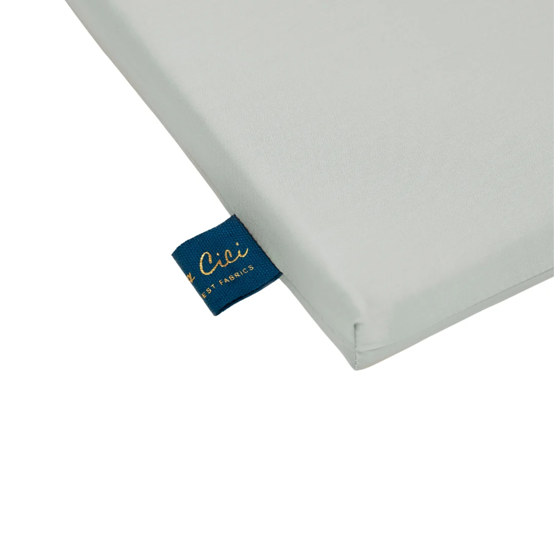 Een close-up van de hoek van de Dekbedovertrek 140x220 Luxe uitstraling in lichtgrijze stof, met een blauw label met gouden tekst.