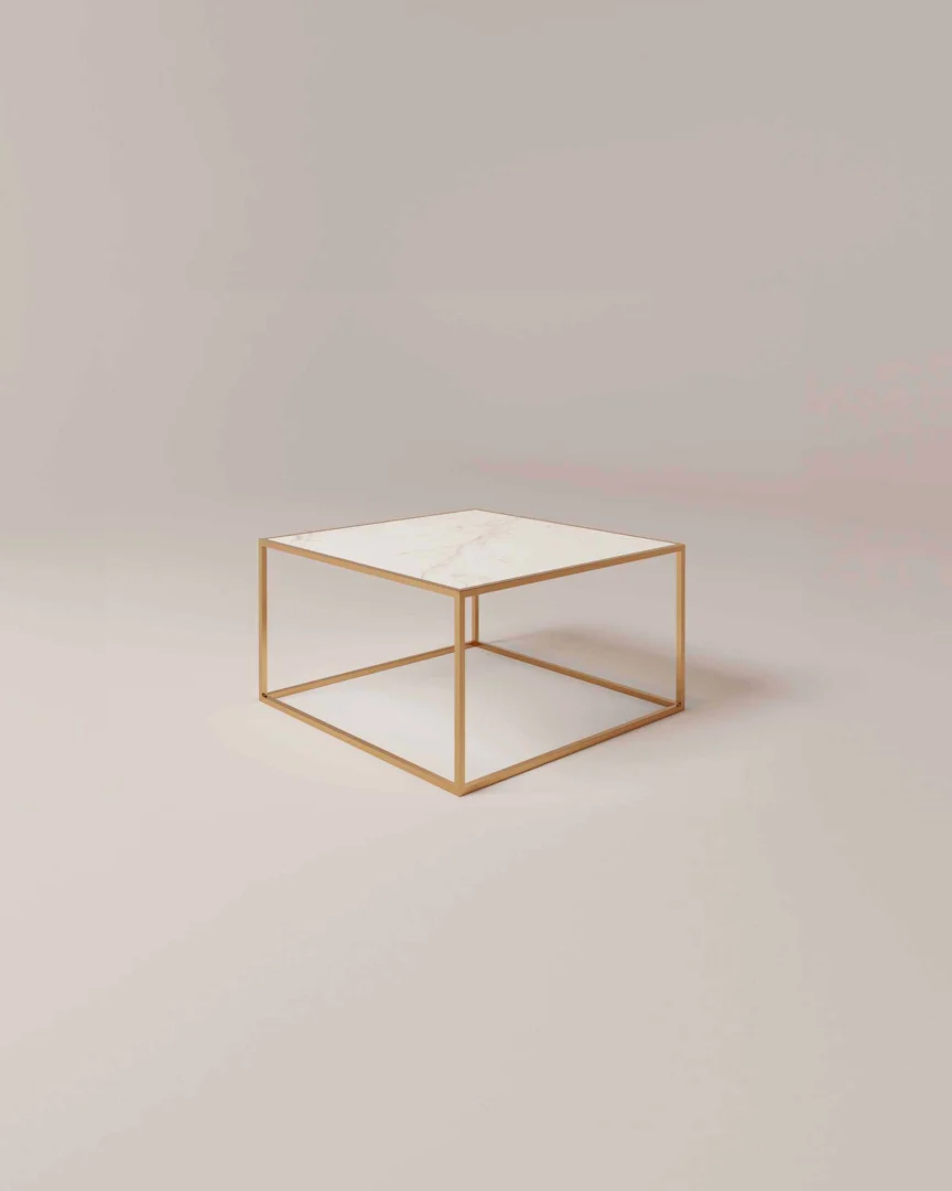 De Salontafel Messing Design Tijdloos Design is een minimalistische vierkante salontafel met een dun goud metalen frame en een wit marmeren blad, afgebeeld tegen een effen lichtbeige achtergrond.