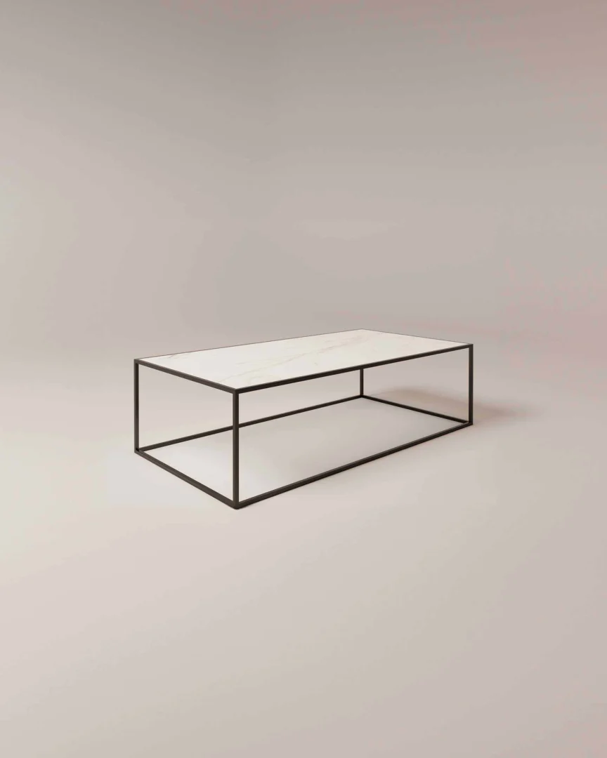 De Salontafel Zwart Design heeft een minimalistisch rechthoekig wit marmeren blad en een dun onderstel van zwart metaal, een mix van industrieel klassiek tegen een lichte achtergrond.
