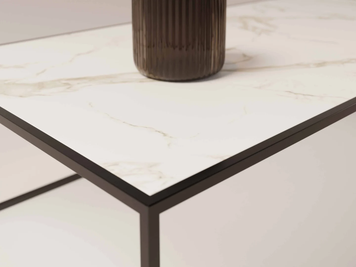 Een close-up van de Salontafel Zwart Design Tijdloos Design, een industrieel klassieke tafel met een wit marmeren blad en zwart metalen onderstel, met een geribbelde donkere vaas die gedeeltelijk op het oppervlak staat.