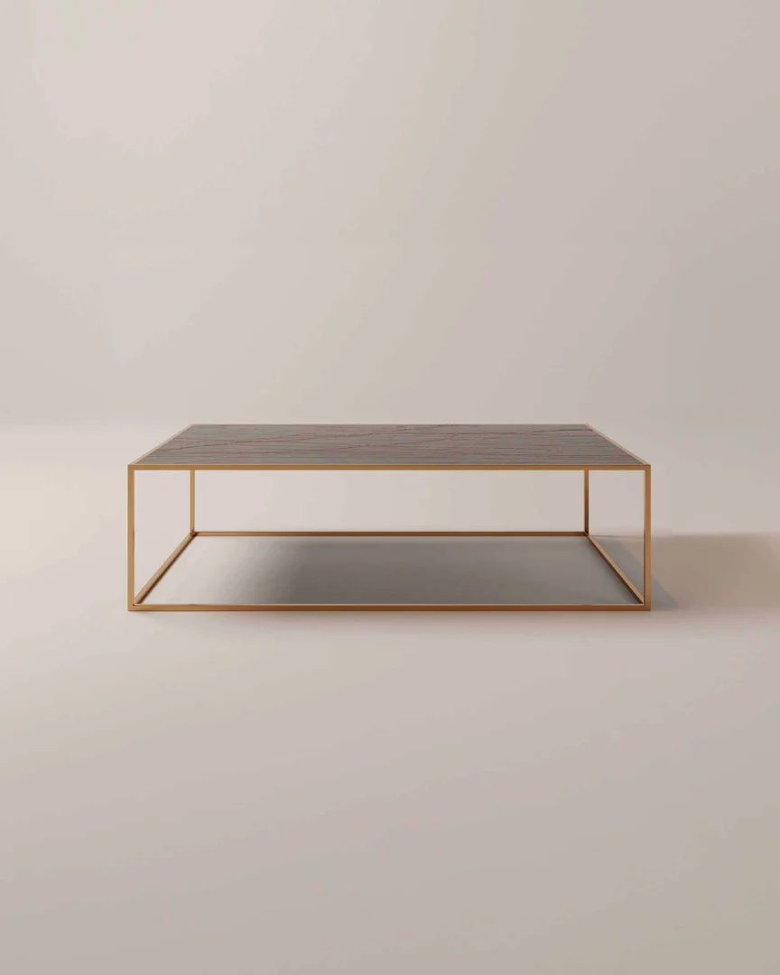 De Salontafel Messing is een minimalistische rechthoekige salontafel met een slank goud metalen frame en een donker houten blad tegen een eenvoudige, lichte achtergrond.