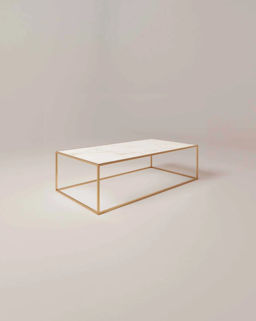 De Salontafel Messing Design is een minimalistische rechthoekige salontafel met een dun, goudkleurig metalen frame en een wit marmeren blad tegen een lichte achtergrond.